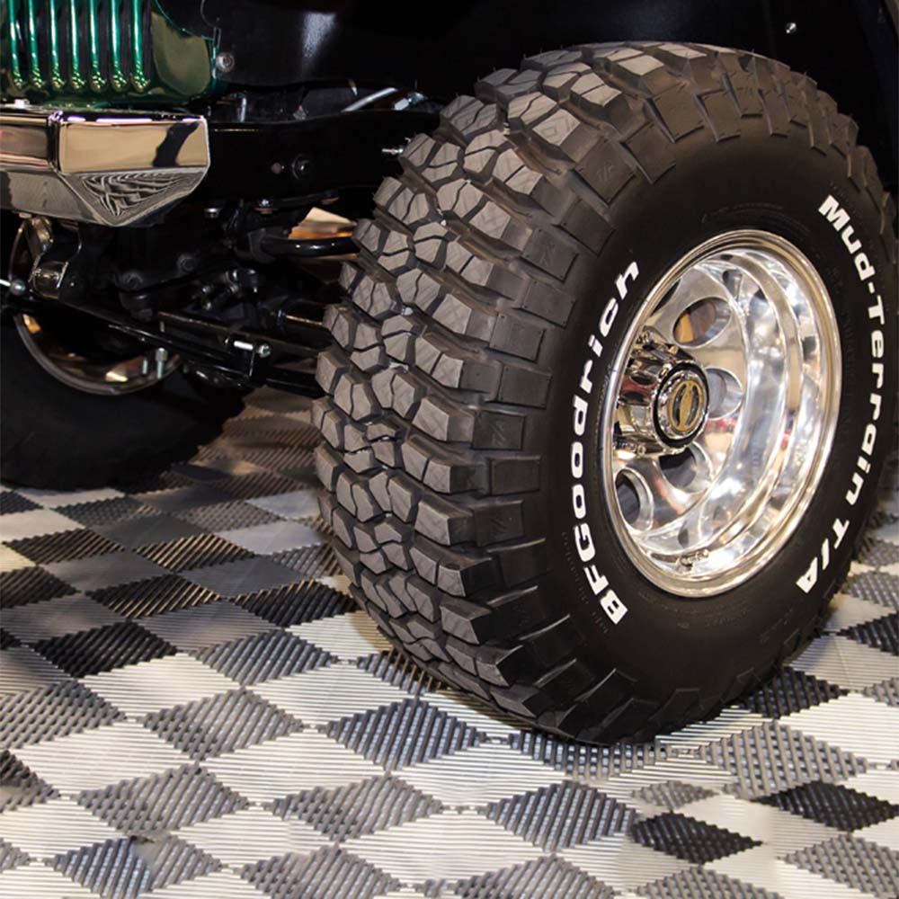 Off Road Tire With An Aggressive Tread Pattern And Patterned Surface Resembling A Protective Racedeck Flooring