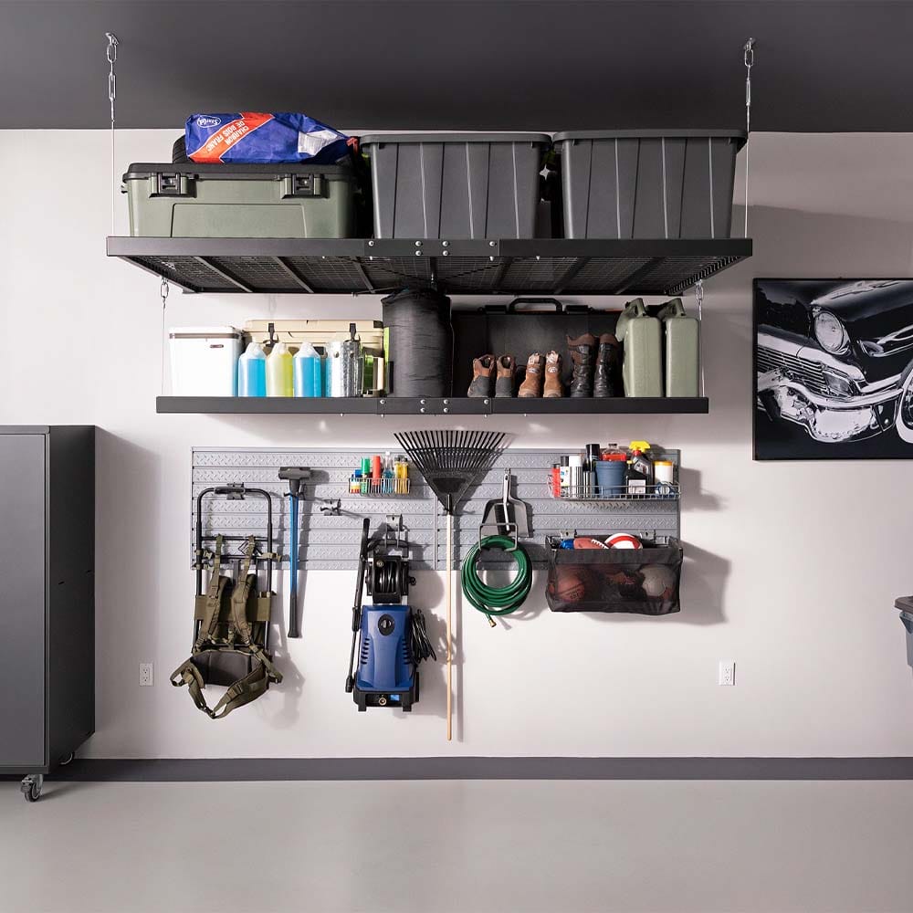 Organized Garage Wall Features Overhead Storage Racks And A Slatwall System Holding Tools Gear And Supplies