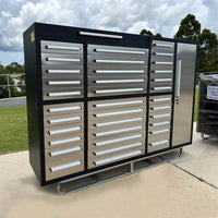 Outdoor View Of A Large Black And Silver Multi Drawer Tool Cabinet With A Tall Locking Side Door