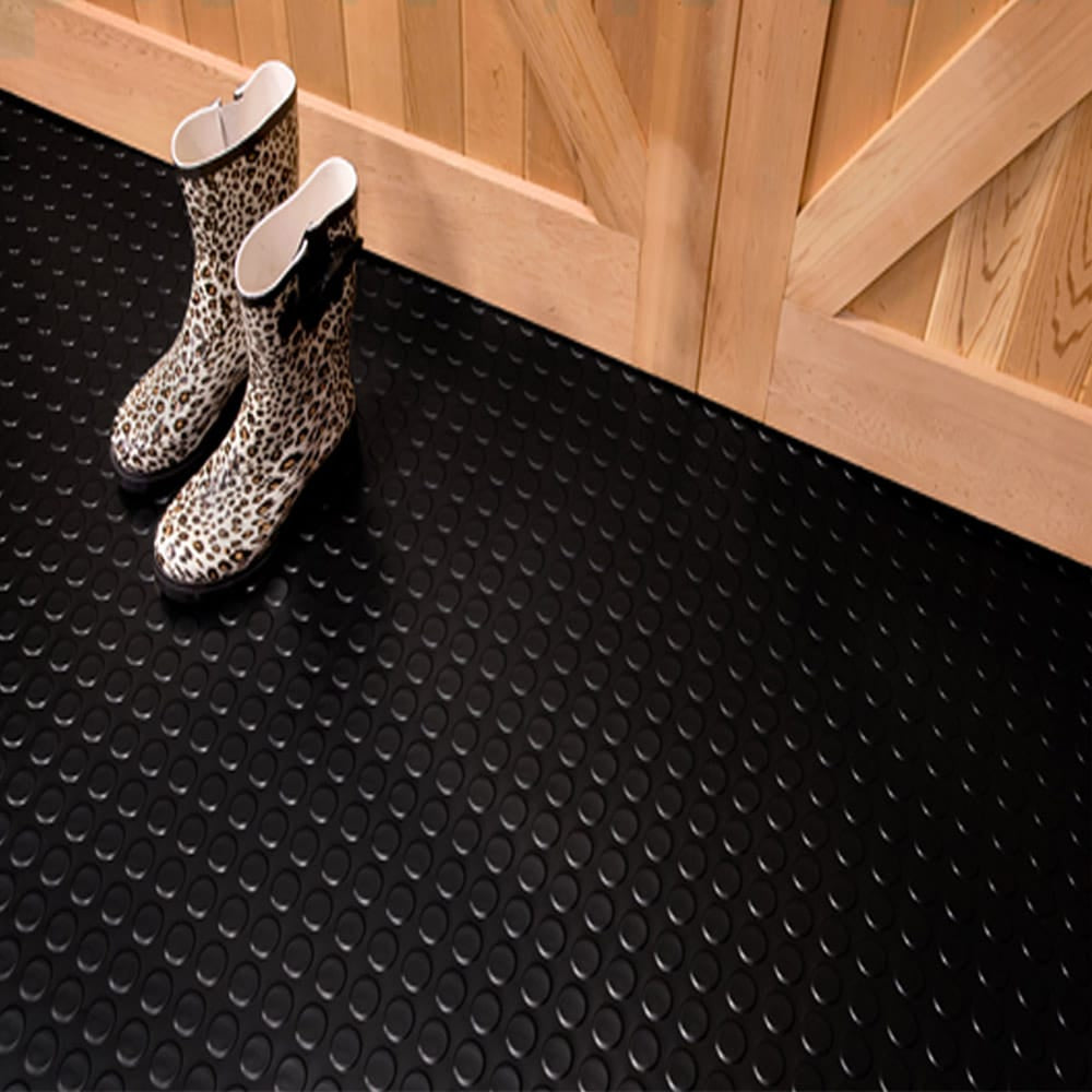 Pair Of Rain Boots Placed On A Black Coin Flooring Tiles With A Textured Circular Pattern