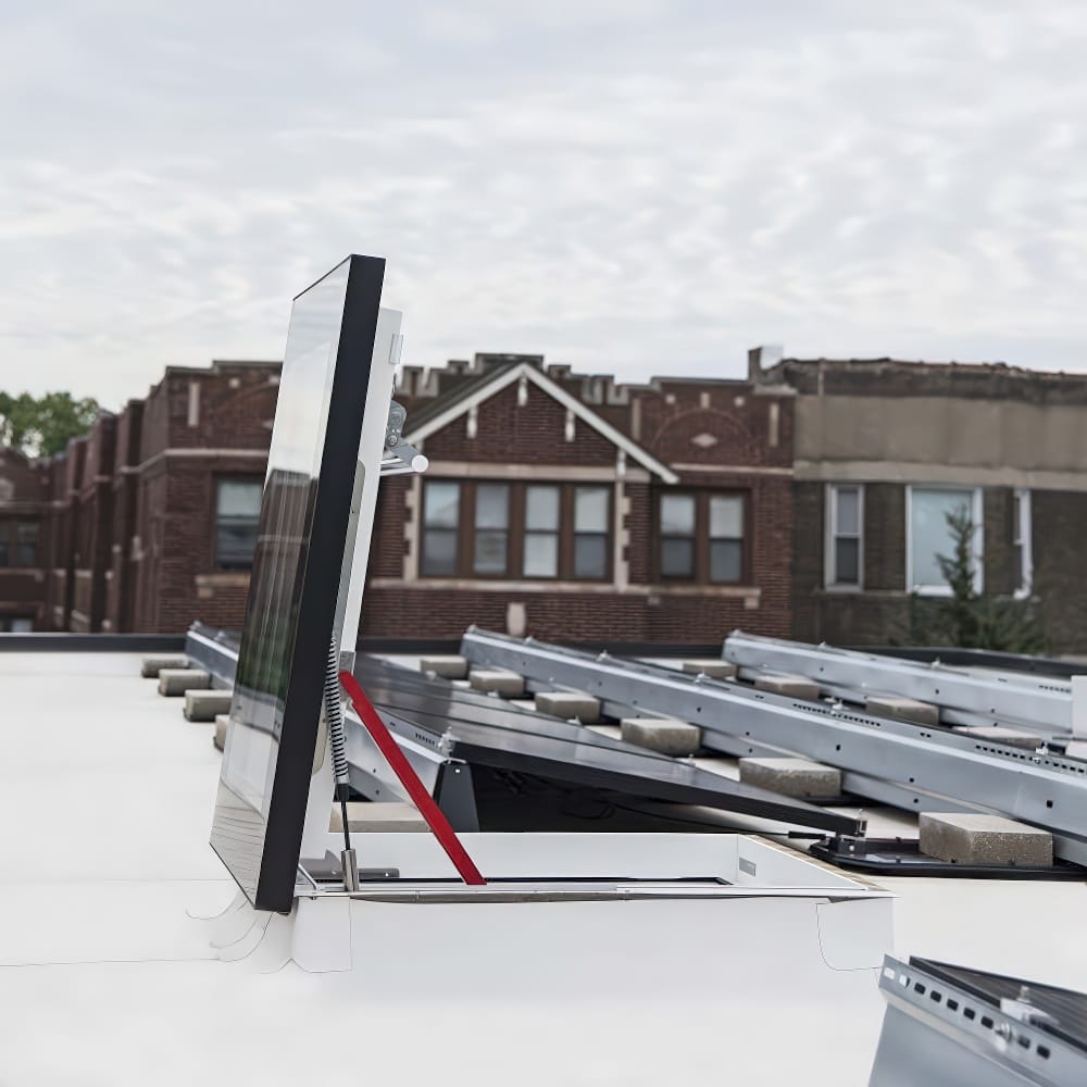 Partially Open Roof Hatch With Glass Top And Red Support Bar On White Rooftop
