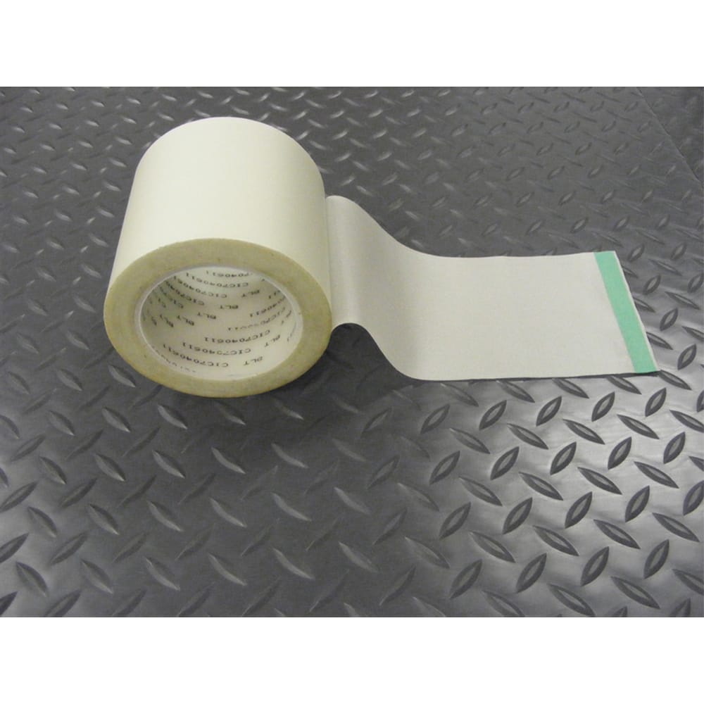 Partially Unrolled White G-Floor Roll-Out Mat Tape Resting On A Textured Metal Surface With A Diamond Plate Pattern