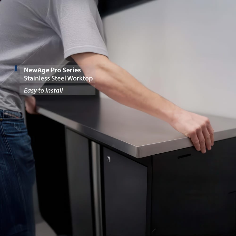 Person Aligns A NewAge Pro Series Stainless Steel Worktop On Black Garage Cabinets During Easy Installation