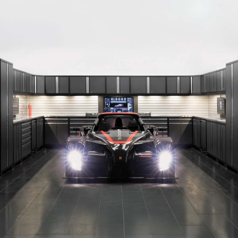 Race Car With Headlights On Parked In A Modern Garage Workshop Surrounded By Sleek Grey Cabinetry
