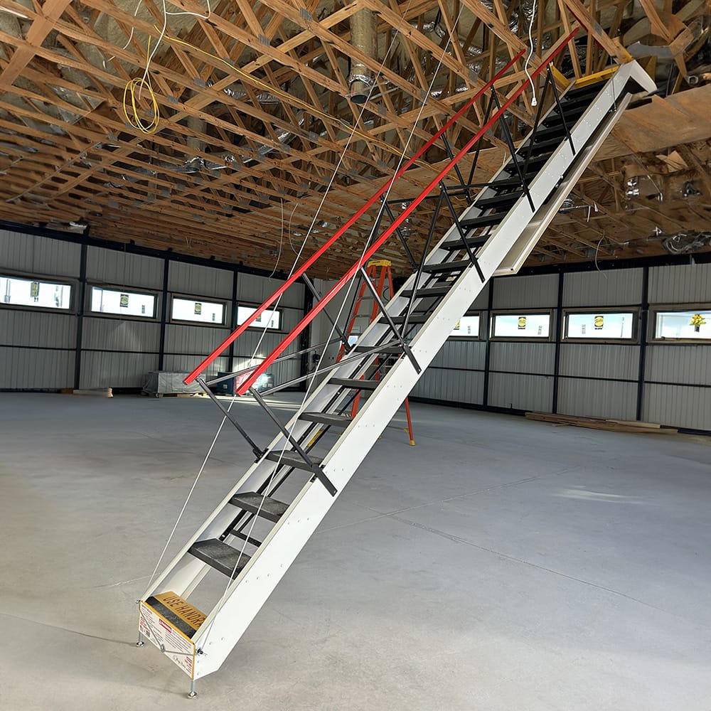 Rough Opening For Attic Stairs with A Red Handrail in A Large Open Warehouse Space