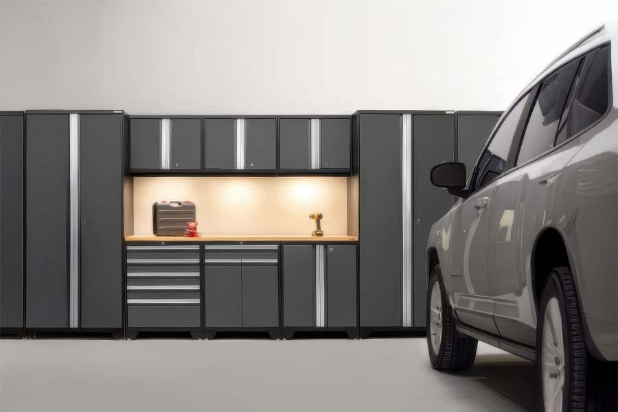 SUV In Modern Garage Facing A Wall Of Dark Gray Modular Cabinets With Illuminated Wood Workbench