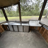 Screened Porch Work Area With Stainless Steel Countertop Drawer Cabinets And A White Utility Sink