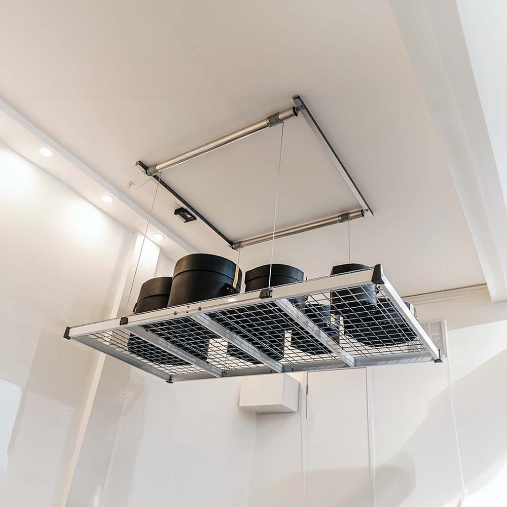 Series Of Black Cylindrical Containers Arranged On A Suspended Metallic Mesh Platform Of AuxxLift Garage Ceiling Storage