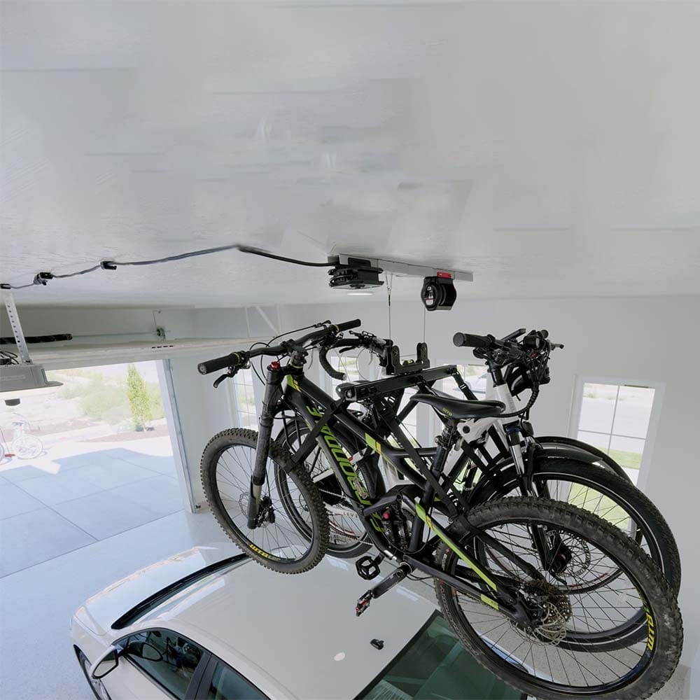 Saveral Bicycles Are Suspended Above A Car In A Garage Using An Overhead Motorized Bike Lift For Garage By SmarterHome