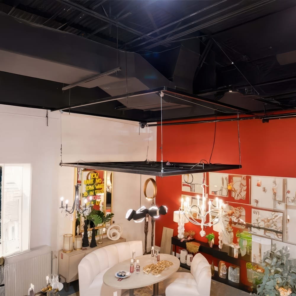 Showroom Featuring Suspended Ceiling Rig Above Modern Dining Set With Mixed Chandeliers Against A Red Accent Wall