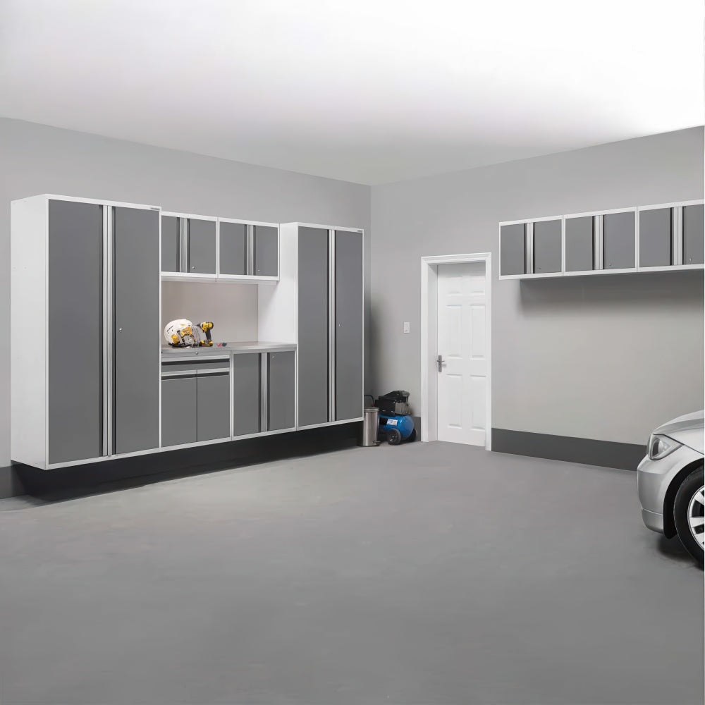Spacious Garage Featuring White Frames With Gray Cabinets A Lit Work Nook Wall Mounted Upper Units A Door And A Silver Car In View