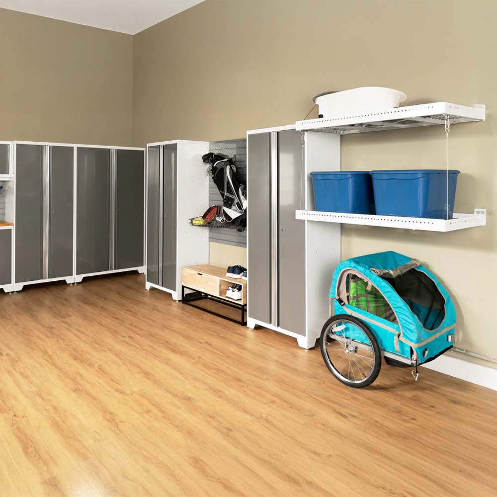 Spacious Garage With Sleek Gray Storage Cabinets A Wall-Mounted Gear Organizer Holding Sports Equipment Floating Shelves With Blue Bins And A Teal Bike Trailer