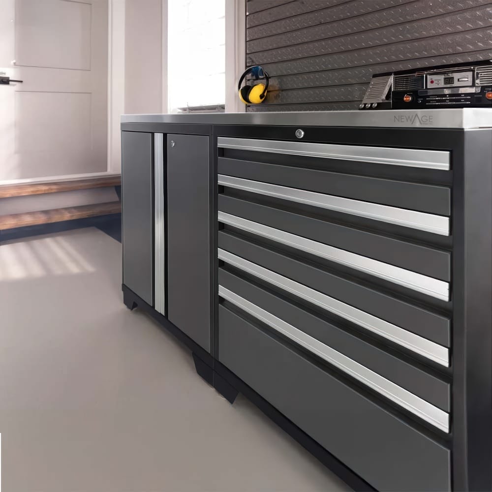 Stainless Countertop Caps Dark Base Cabinets With Slim Pulls And Six Drawer Stack Beside Door And Slatwall Radio