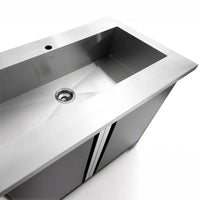 Stainless Steel Utility Sink With Integrated Back Splash Sits Over Tall Two Door Cabinet