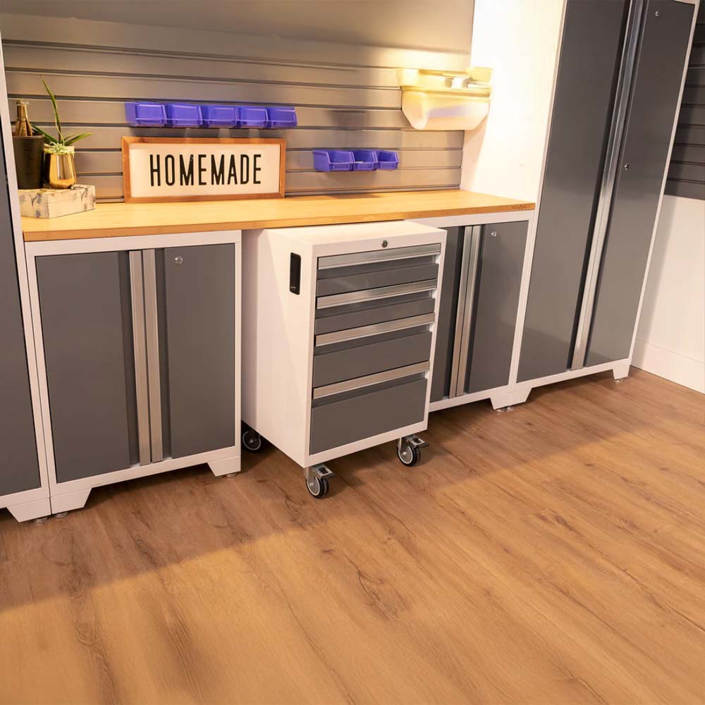 Tidy Garage Workspace With Gray And White Cabinets A Wooden Worktop A Mobile Drawer Unit On Casters And A Wall-Mounted Slat System