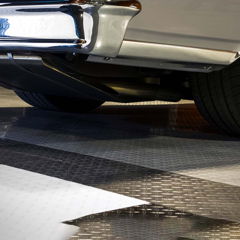 Underside Of A Vehicle Highlighting The Chrome Exhaust System And Rear Suspension Components Parked In A Racedeck Garage Flooring