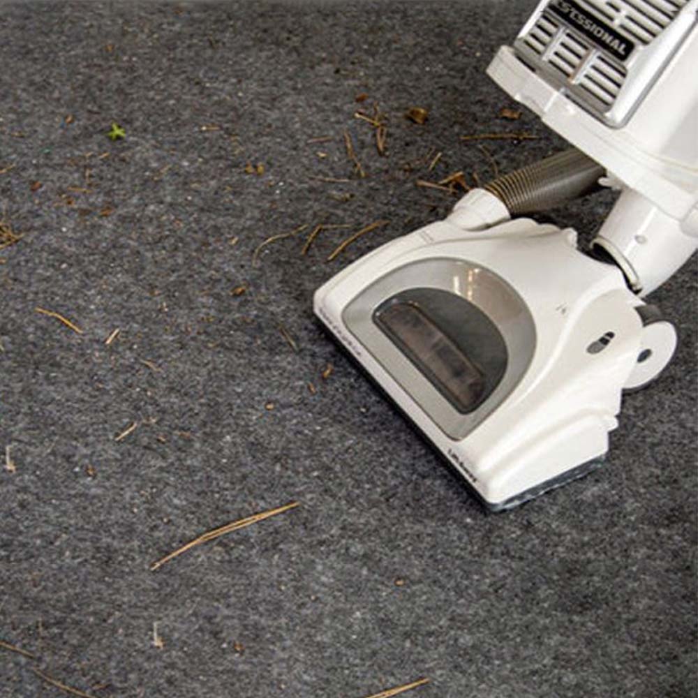 Vacuum Cleaner On A Carpeted G-Floor Garage Flooring Surrounded By Scattered Debris