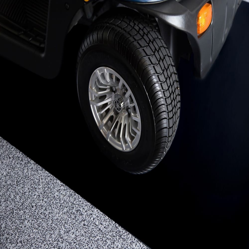 Vehicles Front Wheel Featuring A Robust Tire Set Against A Contrasting Floor Protector Mat By G-Floor