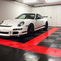 White Porsche Parked In A Well Lit Garage Featuring A Striking Red And Black Checkered Racedeck Tiles